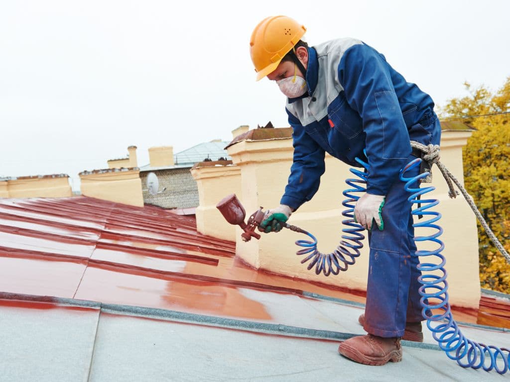 Roofers Spray Painting Metal Roof in Jacksonville FL